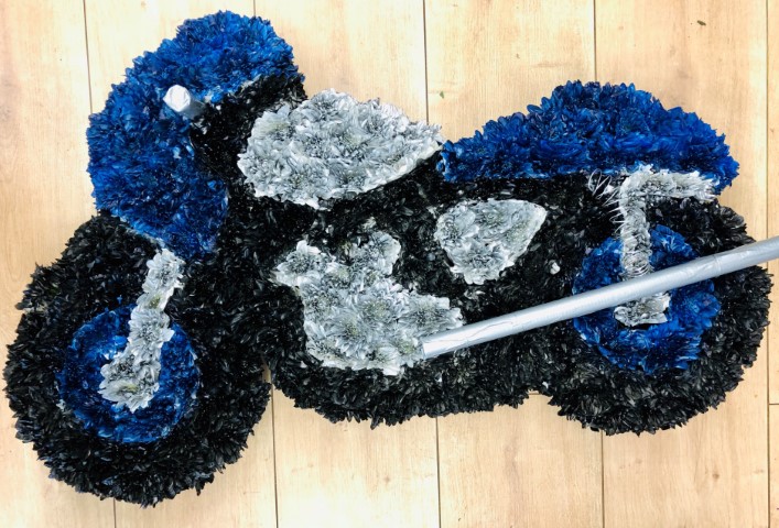 <h2>Blue Motorbike Tribute | Funeral Flowers</h2>
<ul>
<li>Approximate Size 78cm x 46cm</li>
<li>Hand created blue motorbike with silver and black trim</li>
<li>To give you the best we may occasionally need to make substitutes</li>
<li>Funeral Flowers will be delivered at least 2 hours before the funeral</li>
<li>For delivery area coverage see below</li>
</ul>
<br>
<h2>Liverpool Flower Delivery</h2>
<p>We have a wide selection of Bespoke Funeral Tributes offered for Liverpool Flower Delivery. Bespoke Funeral Tributes can be provided for you in Liverpool, Merseyside and we can organize Funeral flower deliveries for you nationwide. Funeral Flowers can be delivered to the Funeral directors or a house address. They can not be delivered to the crematorium or the church.</p>
<br>
<h2>Flower Delivery Coverage</h2>
<p>Our shop delivers funeral flowers to the following Liverpool postcodes L1 L2 L3 L4 L5 L6 L7 L8 L11 L12 L13 L14 L15 L16 L17 L18 L19 L24 L25 L26 L27 L36 L70 If your order is for an area outside of these we can organise delivery for you through our network of florists. We will ask them to make as close as possible to the image but because of the difference in stock and sundry items it may not be exact.</p>
<br>
<h2>Liverpool Funeral Flowers | Bespoke Tributes</h2>
<p>Pay tribute to their love of motorcycles with this distinctive floral display. The motorbike is covered in a bed of fresh carnations and double spray chrysanthemums and finished with silver, blue and black spray colours. It has been loving handcrafted by our expert florists and is an ideal funeral tribute for a motorbike enthusiast.</p>
<p>Bespoke Funeral Tributes are a way to create a tribute that is truly unique and specially designed for a loved one.</p>
<br>
<p>These are sometimes selected by family members as the main tribute or more often a group of friends or workplace colleagues as a symbol of things they associate with the deceased.</p>
<br>
<p>The flowers are arranged in floral foam, which means the flowers have a water source so they look their very best for the day.</p>
<br>
<p>Containing 55 double spray chrysanthemums sprayed in blue, silver and black.</p>
<br>
<h2>Best Florist in Liverpool</h2>
<p>Trust Award-winning Liverpool Florist, Booker Flowers and Gifts, to deliver funeral flowers fitting for the occasion delivered in Liverpool, Merseyside and beyond. Our funeral flowers are handcrafted by our team of professional fully qualified who not only lovingly hand make our designs but hand-deliver them, ensuring all our customers are delighted with their flowers. Booker Flowers and Gifts your local Liverpool Flower shop.</p>
<br>
<p><em>Debera G - 5 Star Review on yell.com - Funeral Florist Liverpool</em></p>
<br>
<p><em>Fleur and her team made the flowers for my Dad's funeral. I knew I wanted something quite specific but was quite unsure how to execute the idea. Fleur understood immediately what I was hoping to achieve and developed the ideas into amazingly beautiful flowers that were just perfect. I honestly can't recommend her highly enough - she created something outstanding and unique for my Dad. Thanks Fleur.</em></p>